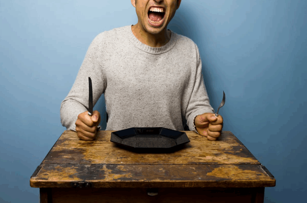 Hungrig man med tallrik utan mat